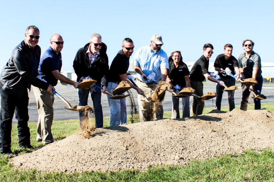 Micah Risher, Easton Airport Manager (middle), shovels dirt with the team at AECOM.