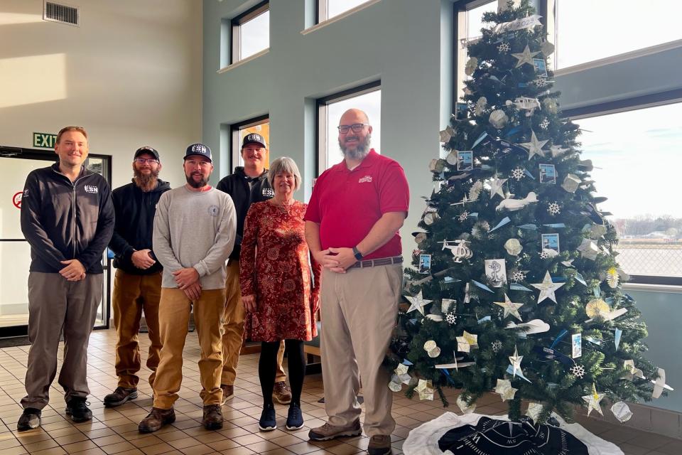 Easton Airport Management team with the 80th anniversary inspired tree that can be seen in the terminal lobby throughout December.