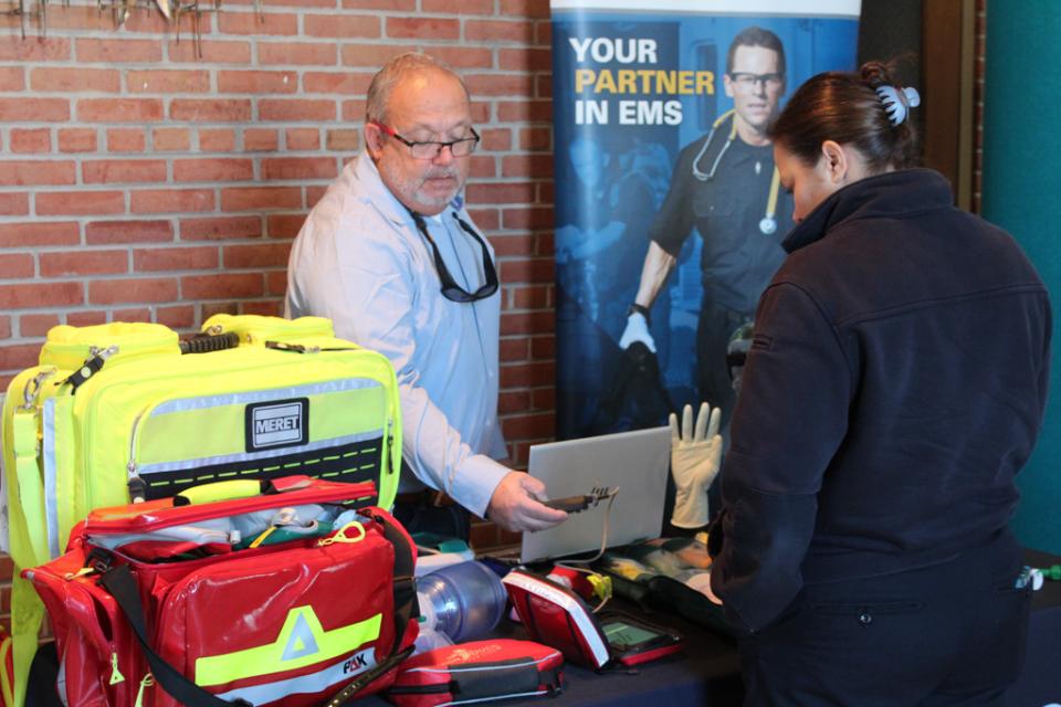 Talbot County Department of Emergency Services EMS Division Chief reviews medical tools at an exhibitors table during Winterfest.