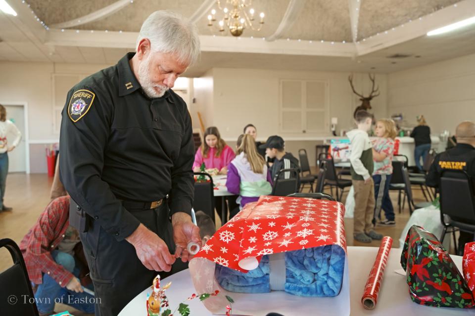 Capt. Bollinger stays focused on wrapping a present during the &#039;Shop with a Cop&#039; event.